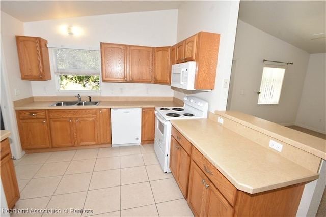 kitchen featuring lofted ceiling, sink, light tile patterned floors, and white appliances