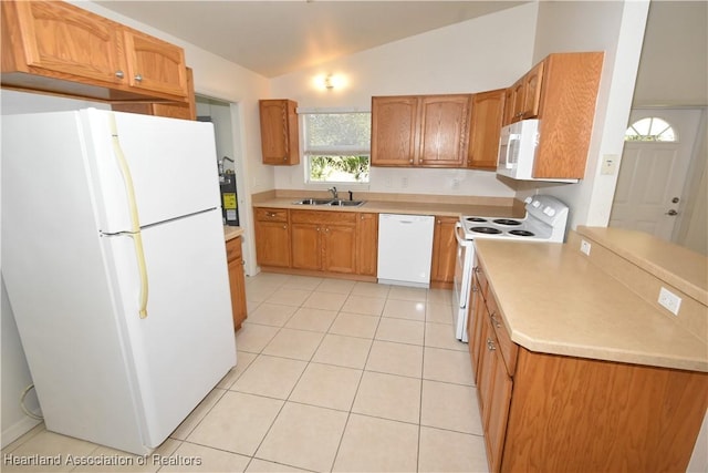 kitchen featuring light tile patterned flooring, white appliances, vaulted ceiling, and sink