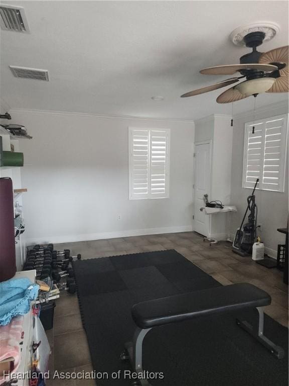 exercise area featuring ceiling fan, tile patterned flooring, and crown molding