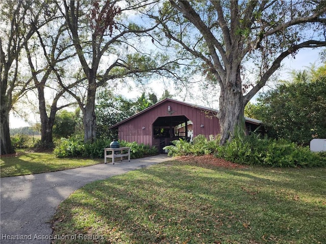 view of front of property featuring a front yard, an outdoor structure, and a pole building