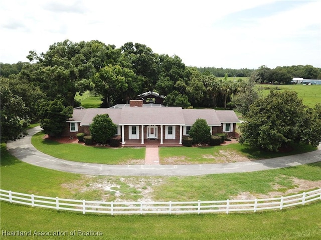 ranch-style home with a porch and a chimney