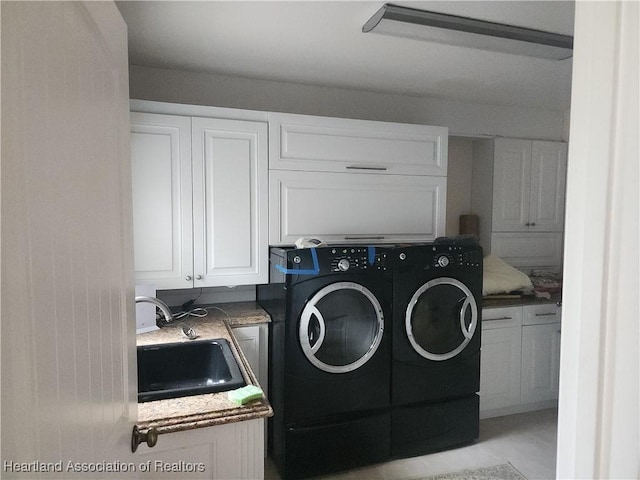 laundry area featuring separate washer and dryer and cabinet space