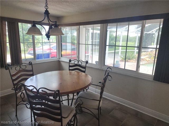 dining area with a textured ceiling and baseboards