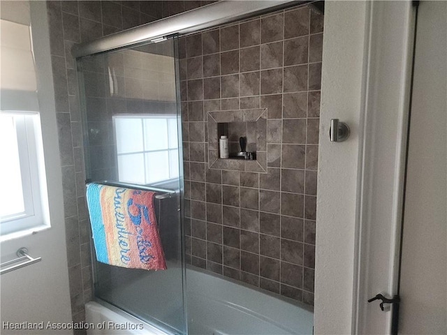 bathroom featuring bath / shower combo with glass door and healthy amount of natural light