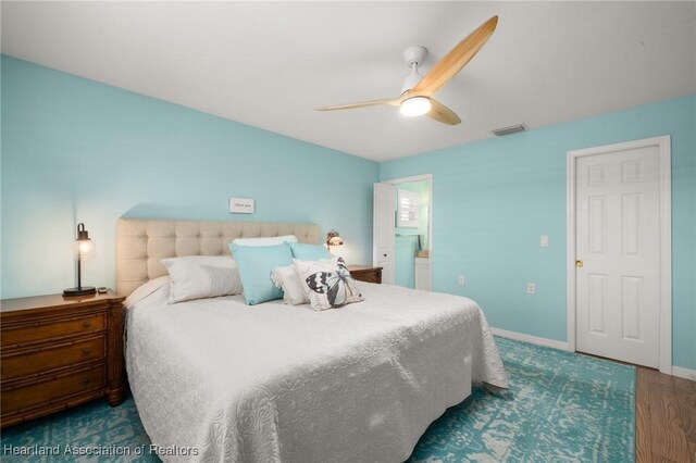 bedroom with a ceiling fan, visible vents, wood finished floors, and baseboards