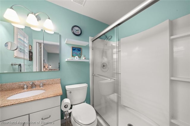 bathroom with toilet, visible vents, a shower stall, and vanity