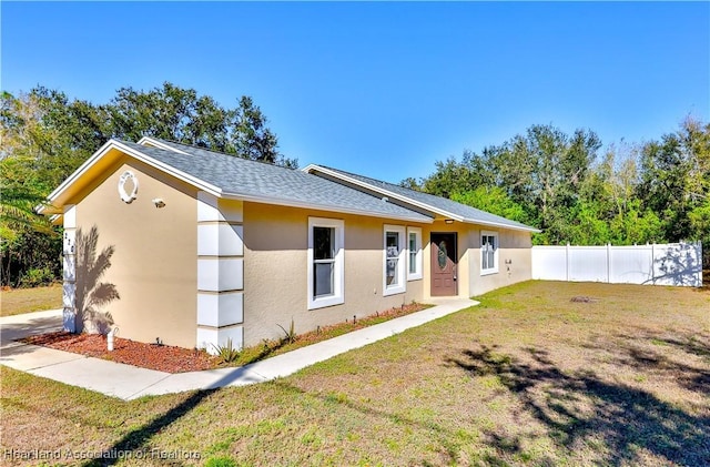 single story home featuring a front lawn