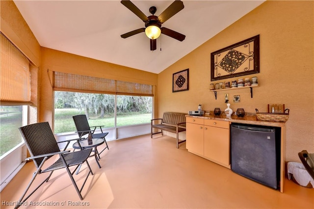 interior space featuring ceiling fan, refrigerator, lofted ceiling, and a healthy amount of sunlight