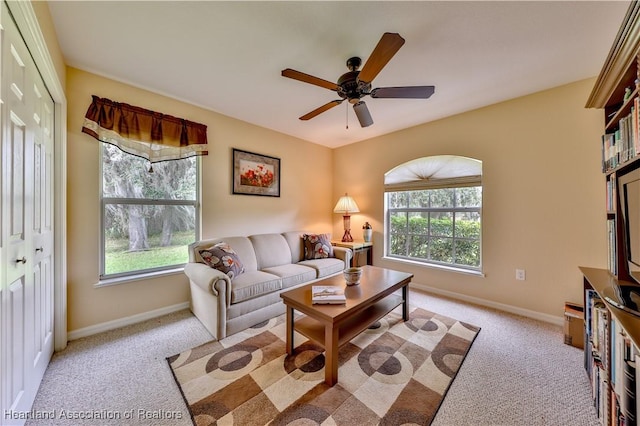 carpeted living room with ceiling fan