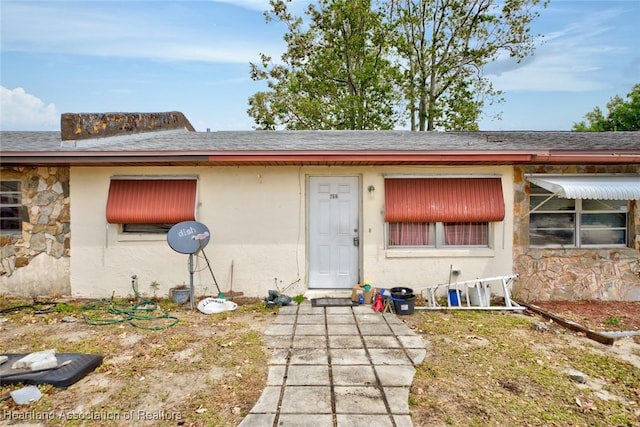 612 Denise Ave, Sebring, FL 33870 - doorway to property with stucco siding, stone siding, and roof with shingles