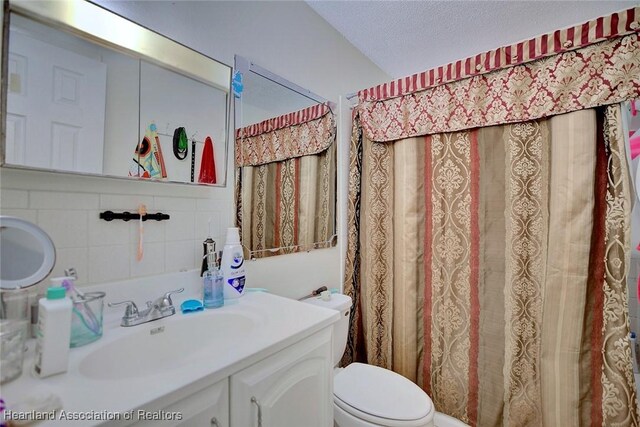 612 Denise Ave, Sebring, FL 33870 - full bath featuring tile walls, a textured ceiling, toilet, curtained shower, and vanity