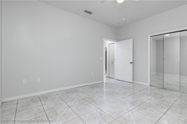 unfurnished bedroom with ceiling fan, a closet, and light tile patterned floors