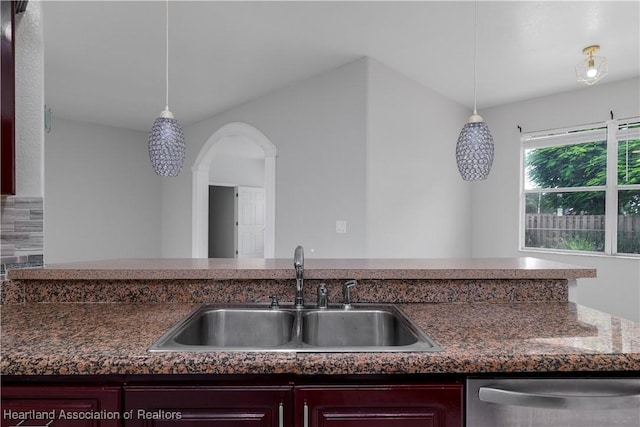 kitchen featuring decorative light fixtures, stainless steel dishwasher, and sink