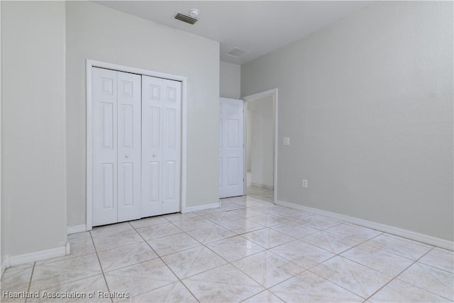 unfurnished bedroom with a closet and light tile patterned floors