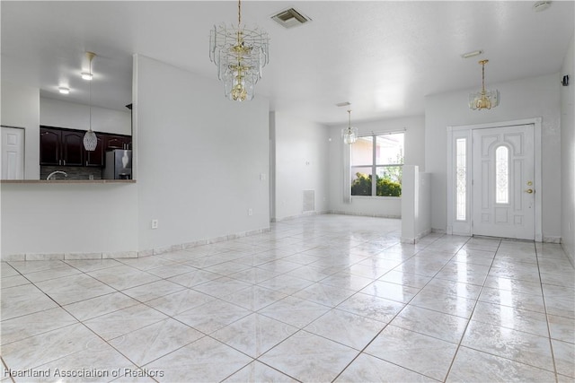 entryway featuring light tile patterned floors and an inviting chandelier