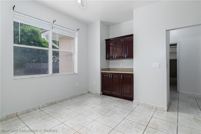 interior space featuring dark brown cabinets and light tile patterned floors