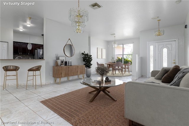 living room with light tile patterned floors and a notable chandelier