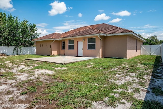 rear view of property featuring a yard and a patio