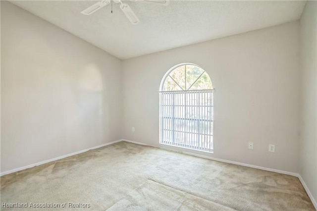 carpeted spare room featuring ceiling fan