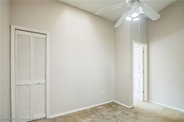 unfurnished bedroom featuring ceiling fan, light colored carpet, and a closet