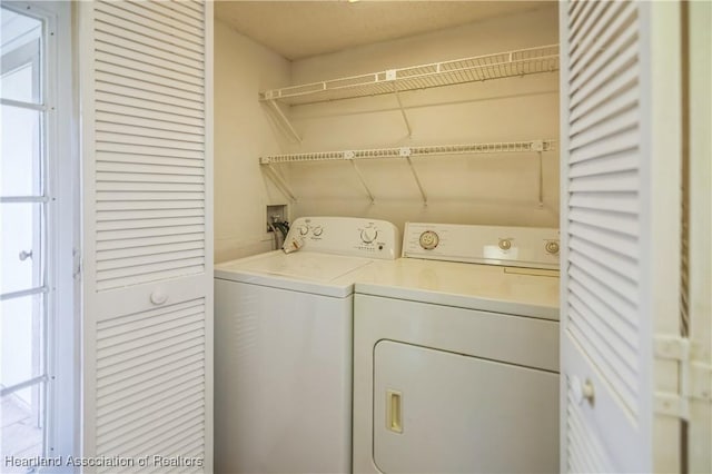 washroom with a wealth of natural light and washer and dryer