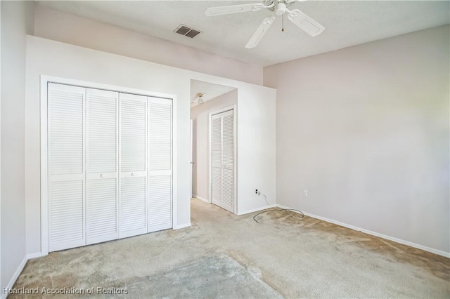 unfurnished bedroom with ceiling fan, light carpet, and a closet