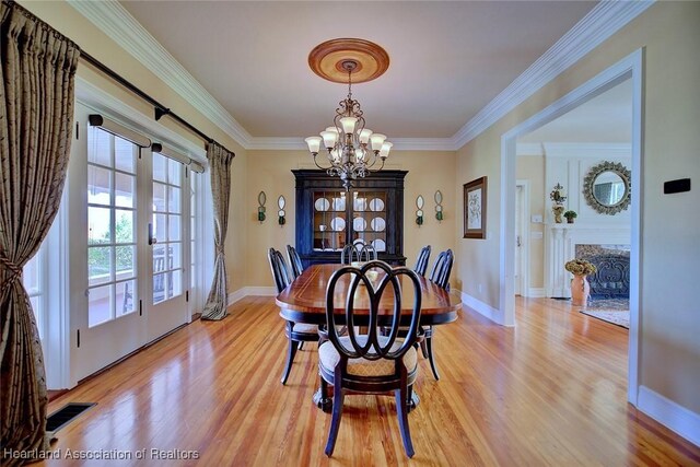 1831 Lakeview Dr, Sebring, FL 33870 - dining area with light wood-style flooring, a chandelier, ornamental molding, and baseboards