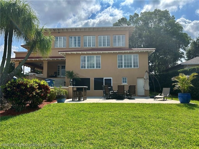 1831 Lakeview Dr, Sebring, FL 33870 - back of house with stucco siding, a patio, and a lawn