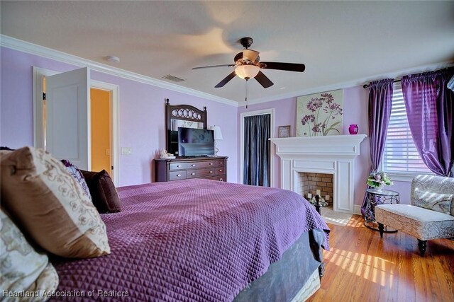 1831 Lakeview Dr, Sebring, FL 33870 - bedroom featuring wood finished floors, crown molding, a fireplace, and ceiling fan