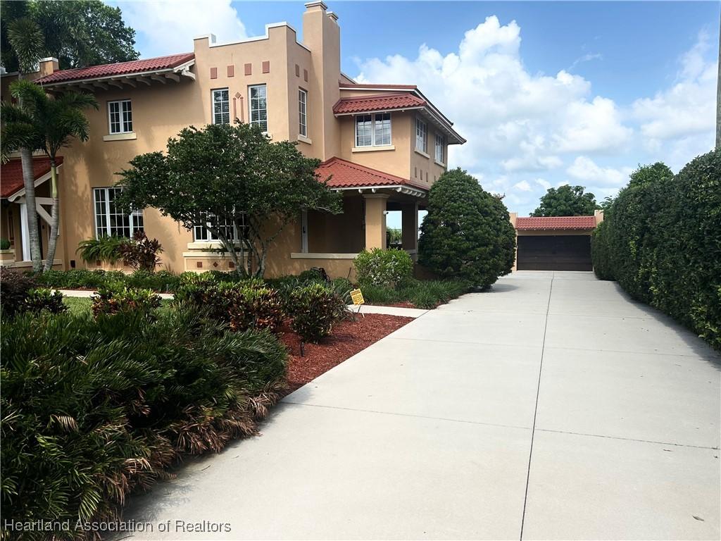 1831 Lakeview Dr, Sebring, FL 33870 - view of front of home with a tiled roof, stucco siding, and a chimney