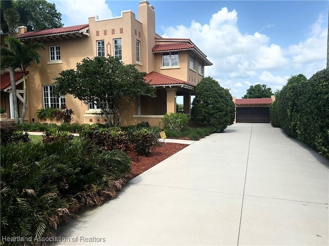 1831 Lakeview Dr, Sebring, FL 33870 - view of front of home with a tiled roof, stucco siding, and a chimney