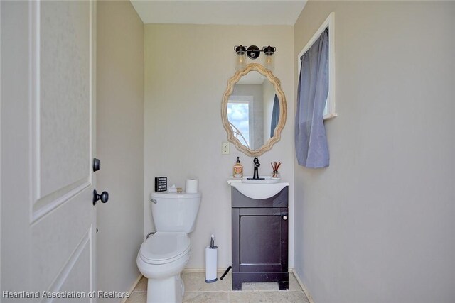 1831 Lakeview Dr, Sebring, FL 33870 - half bathroom with vanity, toilet, tile patterned flooring, and baseboards