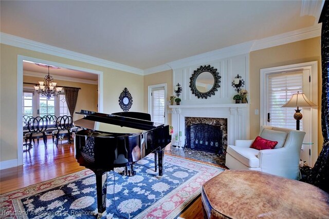 1831 Lakeview Dr, Sebring, FL 33870 - living room with a chandelier, crown molding, wood finished floors, a high end fireplace, and baseboards
