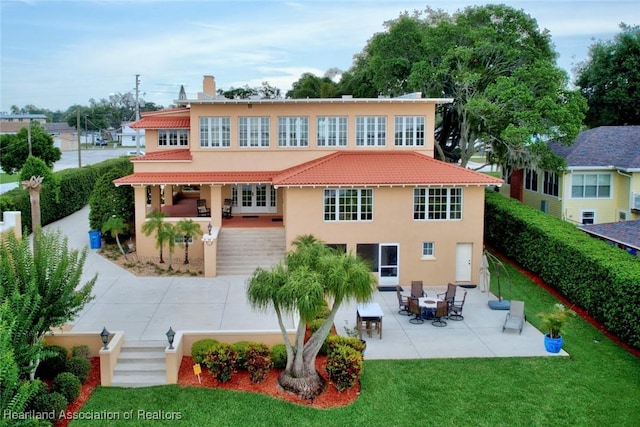 1831 Lakeview Dr, Sebring, FL 33870 - back of house with stucco siding, a patio area, a lawn, and a tiled roof