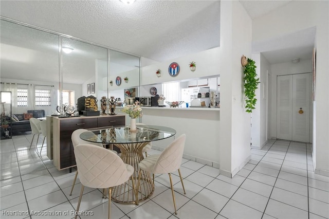 18210 Mediterranean Blvd Unit 5-20, Hialeah, FL 33015 - dining room featuring vaulted ceiling, light tile patterned floors, and a textured ceiling