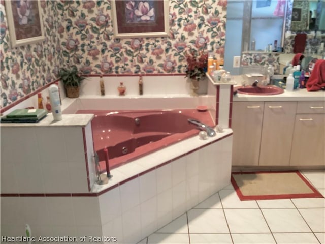 bathroom featuring tiled bath, tile patterned flooring, and vanity