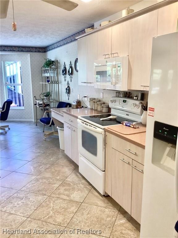 2831 Sunrise Dr, Sebring, FL 33872 - kitchen with white appliances, light tile patterned flooring, wallpapered walls, and light countertops