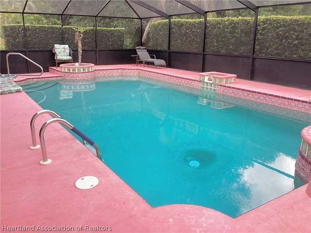 view of swimming pool featuring glass enclosure