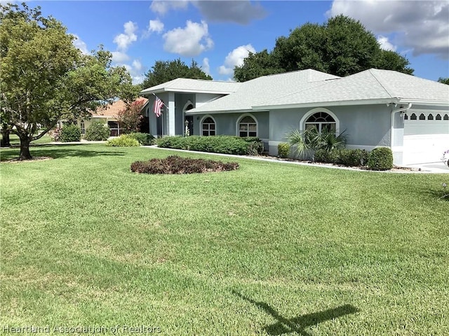 view of front of house with a garage and a front lawn