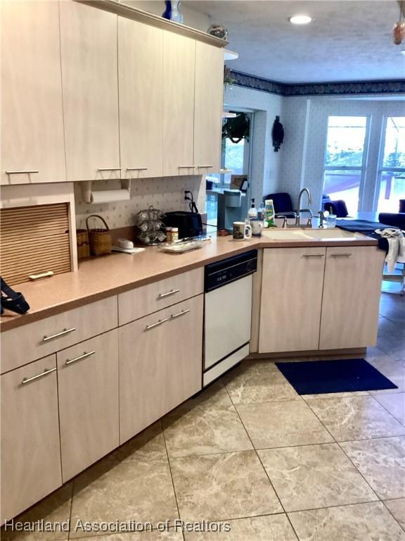 2831 Sunrise Dr, Sebring, FL 33872 - kitchen with white dishwasher, a sink, a wealth of natural light, and light countertops