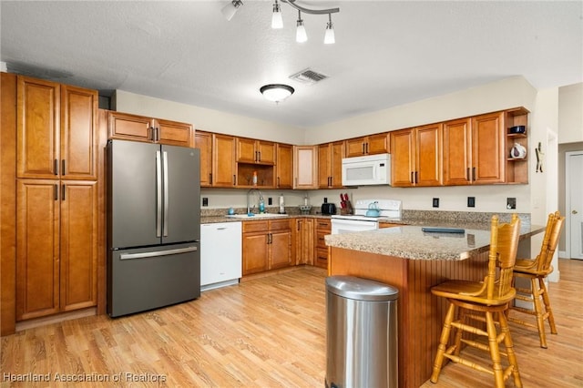 kitchen featuring visible vents, open shelves, a sink, and white appliances