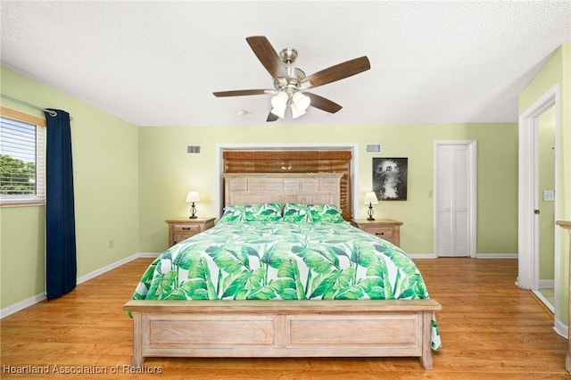 bedroom with baseboards, light wood finished floors, and visible vents