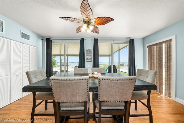 dining space with visible vents, a wealth of natural light, and light wood-style flooring