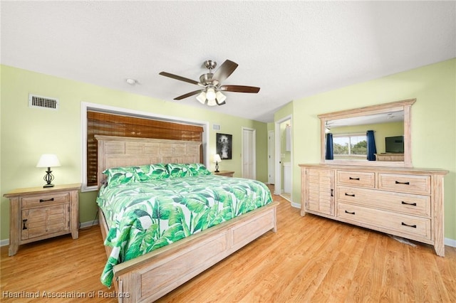 bedroom featuring baseboards, ceiling fan, light wood-type flooring, and visible vents
