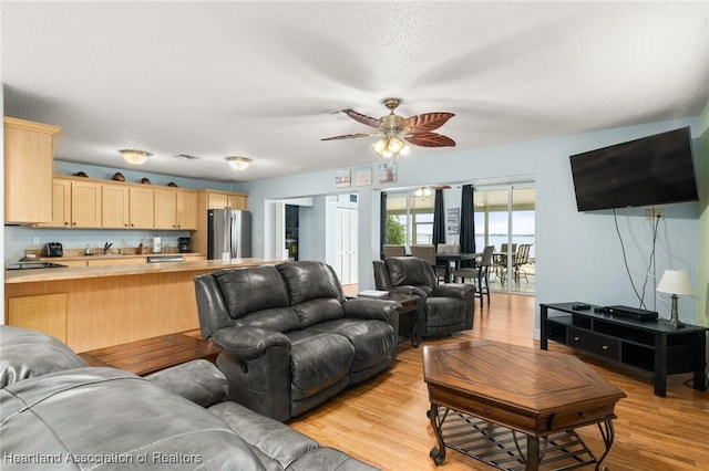 living area featuring a ceiling fan and light wood-style flooring