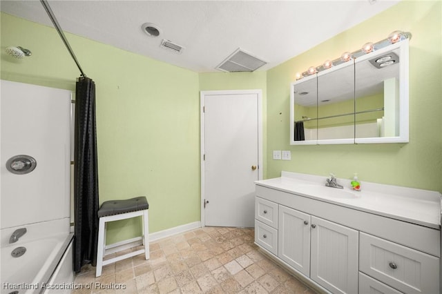 full bath with vanity, baseboards, shower / bathing tub combination, visible vents, and stone tile flooring