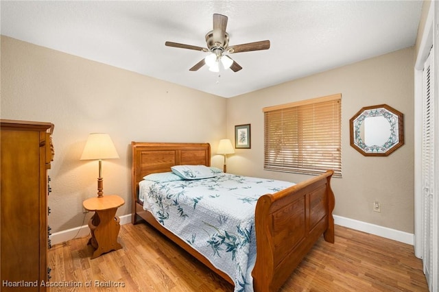 bedroom with baseboards, light wood-style floors, ceiling fan, and a closet
