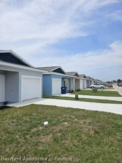 exterior space with a garage and a lawn