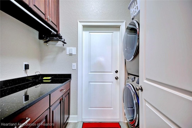 3013 Royal Oaks Ct, Sebring, FL 33875 - laundry area featuring stacked washer / drying machine, cabinet space, and a textured wall