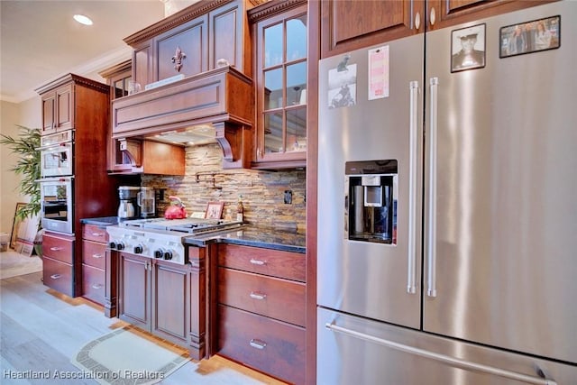 3013 Royal Oaks Ct, Sebring, FL 33875 - kitchen featuring stainless steel appliances, decorative backsplash, dark stone counters, ornamental molding, and light wood-style flooring